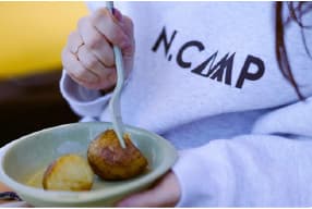 WAENでキャンプ飯の焼き芋を取り分ける宿泊者